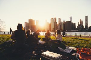Friends having picnic on the river with the city skyline in the background