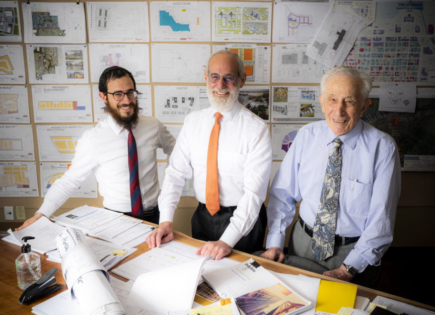 Smiling Businessmen in Suits with Blueprints