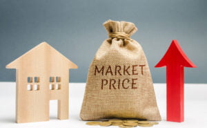 Money bag with the word Market price and an up arrow with a coins and wooden house. The concept of increasing housing prices. Rising rent. Real estate market growth